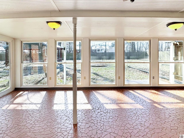 unfurnished sunroom with beamed ceiling