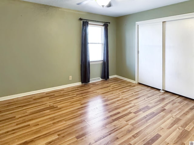 unfurnished bedroom featuring a ceiling fan, light wood-type flooring, a closet, and baseboards