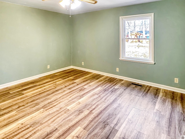 unfurnished room featuring ceiling fan, visible vents, light wood-style flooring, and baseboards