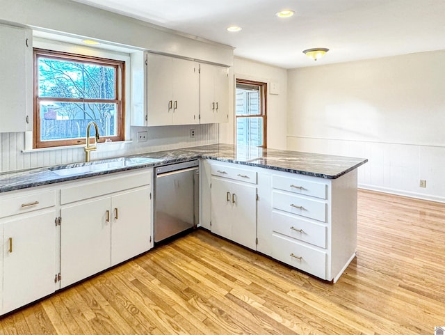 kitchen featuring a peninsula, a sink, white cabinetry, light wood-style floors, and dishwasher