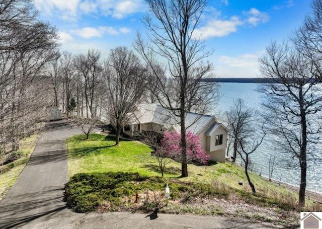 view of front of property featuring driveway, a water view, and a front yard