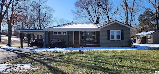 view of front of house with an outdoor structure, driveway, a yard, a carport, and a storage unit