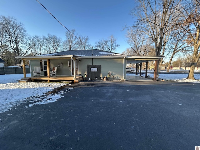 view of front of house with aphalt driveway, an attached carport, and metal roof