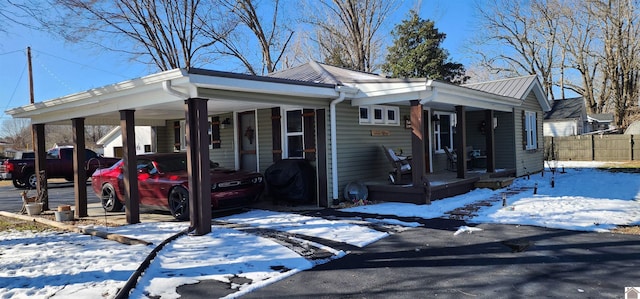 view of front facade with covered porch, fence, and an attached carport