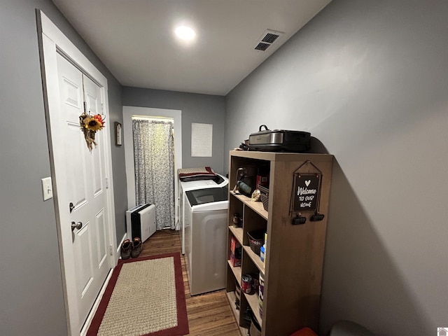 laundry room featuring laundry area, wood finished floors, washing machine and clothes dryer, and visible vents