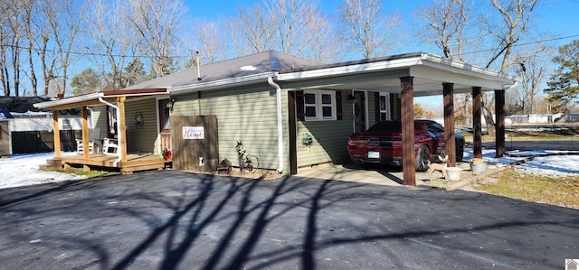 view of side of home featuring aphalt driveway and an attached carport