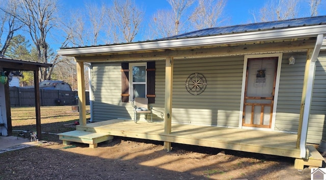 exterior space featuring metal roof and fence