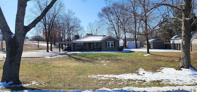 view of front of home with a lawn, an outbuilding, fence, a storage unit, and a carport