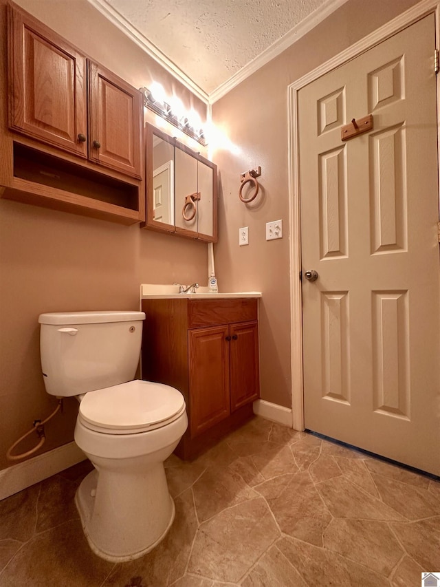 bathroom with a textured ceiling, toilet, vanity, baseboards, and crown molding