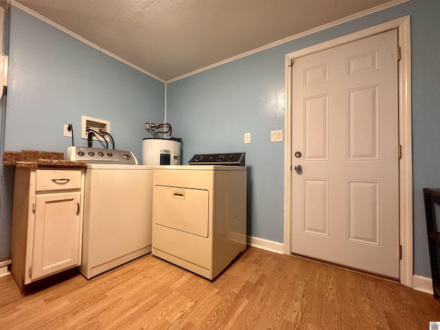 clothes washing area with cabinet space, electric water heater, washing machine and clothes dryer, crown molding, and light wood-type flooring