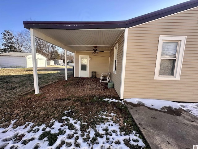 exterior space with a carport, a ceiling fan, and an outbuilding