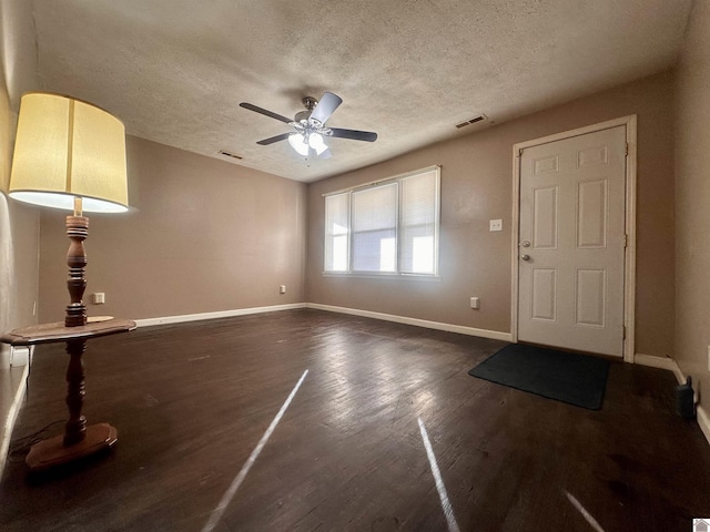 entryway featuring dark wood-style flooring, visible vents, ceiling fan, a textured ceiling, and baseboards