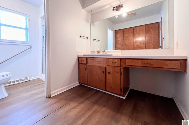 bathroom with visible vents, baseboards, toilet, wood finished floors, and vanity