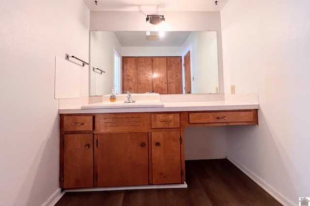 bathroom with vanity, wood finished floors, and baseboards