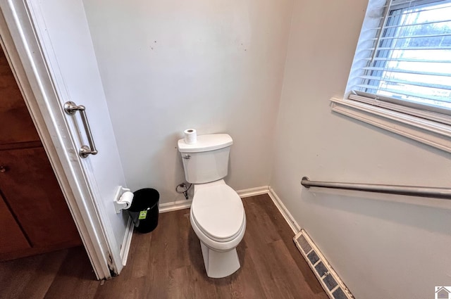 bathroom with visible vents, toilet, baseboards, and wood finished floors