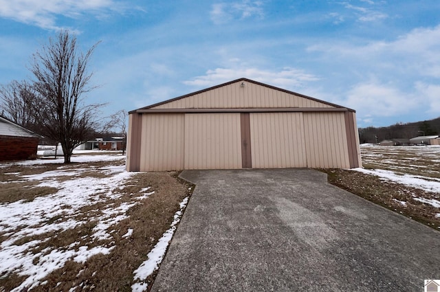 snow covered garage featuring a garage