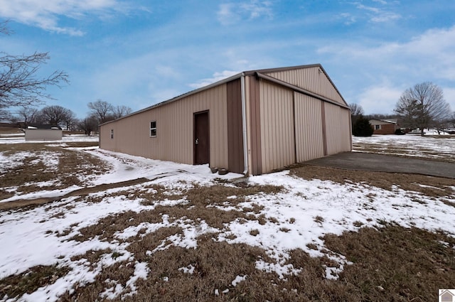 snow covered structure with an outdoor structure and an outbuilding