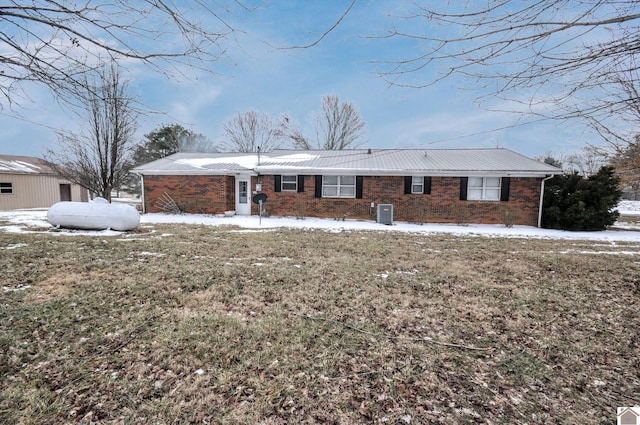 ranch-style house with metal roof, brick siding, and a yard