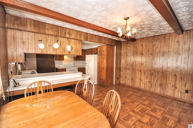 dining room featuring beamed ceiling, a notable chandelier, baseboards, and wooden walls