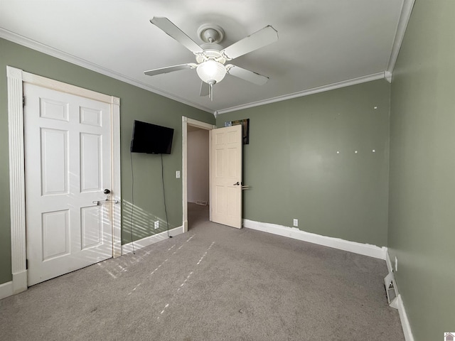 unfurnished bedroom with carpet floors, crown molding, baseboards, and ceiling fan