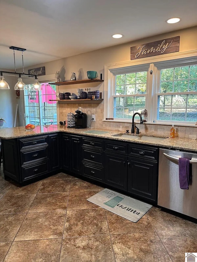 kitchen with tasteful backsplash, dark cabinets, hanging light fixtures, stainless steel dishwasher, and a sink