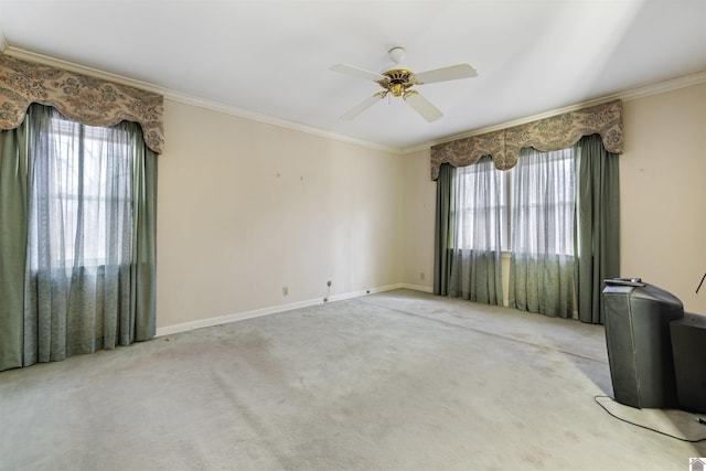 spare room with crown molding, light colored carpet, and a healthy amount of sunlight