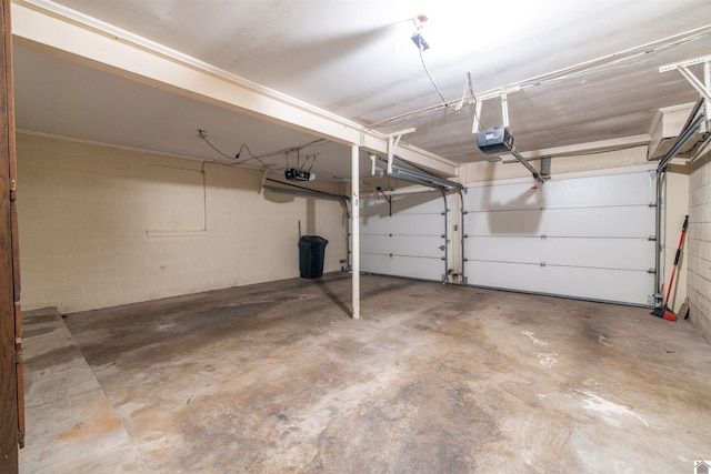 garage with concrete block wall and a garage door opener