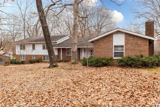 view of front of house featuring brick siding and a chimney