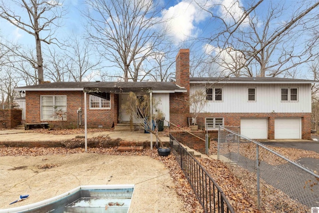 view of front of home featuring a garage, brick siding, a chimney, and aphalt driveway