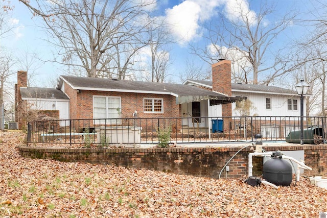 rear view of property with brick siding and a chimney