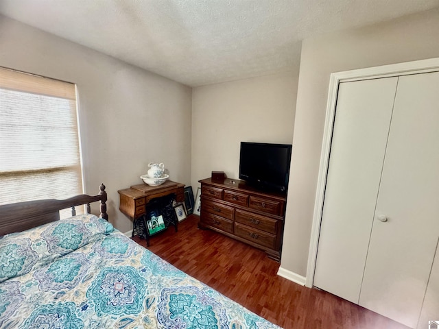 bedroom with a textured ceiling and dark wood-type flooring