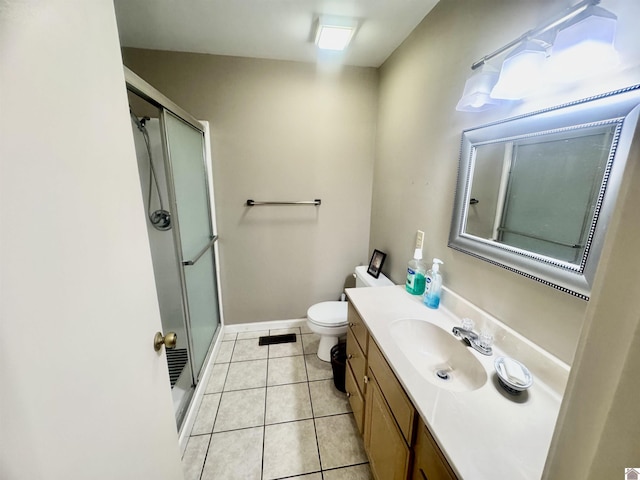 bathroom with tile patterned flooring, toilet, vanity, baseboards, and a stall shower