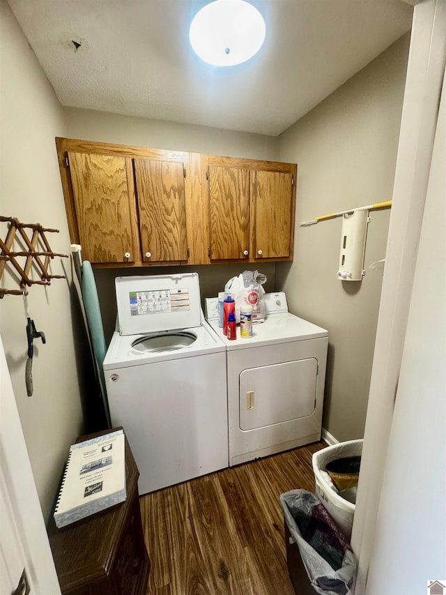 laundry area featuring dark wood-style floors, washer and dryer, and cabinet space