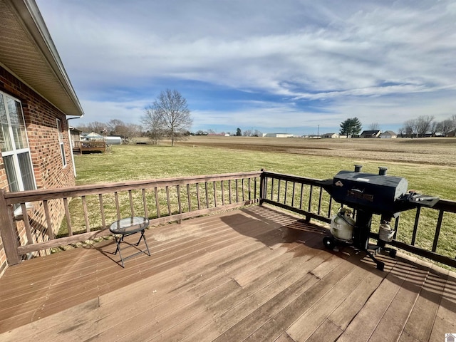 deck with a rural view, grilling area, and a yard