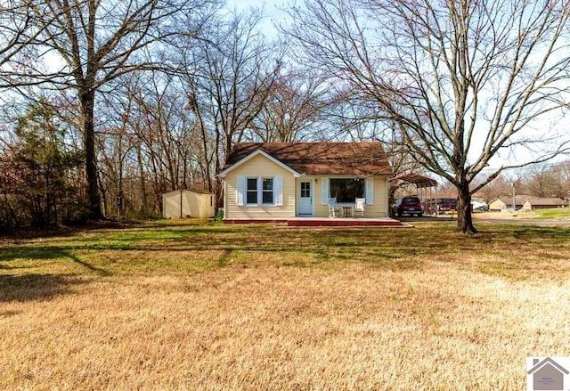 view of front of home featuring a storage unit, a front lawn, and an outdoor structure