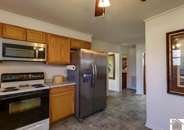 kitchen with stainless steel appliances, light countertops, visible vents, brown cabinetry, and a ceiling fan