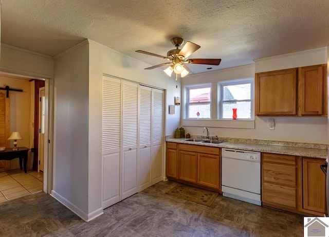 kitchen featuring brown cabinets, light countertops, a barn door, white dishwasher, and a sink