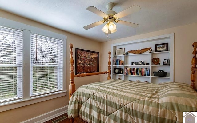 bedroom with baseboards, visible vents, and ceiling fan