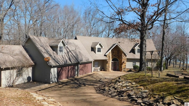 view of front of house featuring stone siding and driveway