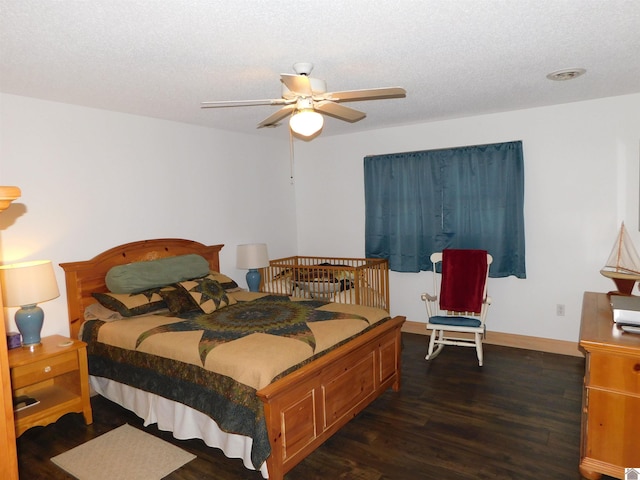 bedroom with dark wood-type flooring, ceiling fan, a textured ceiling, and baseboards