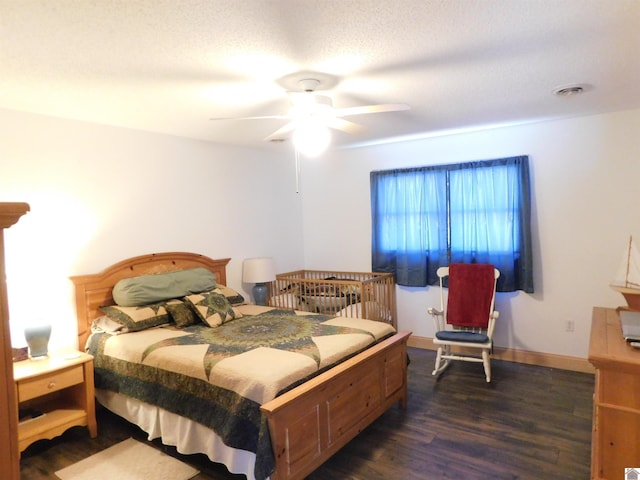 bedroom with dark wood-style flooring, visible vents, a ceiling fan, a textured ceiling, and baseboards