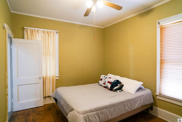 bedroom featuring dark wood-style floors, baseboards, a ceiling fan, and crown molding