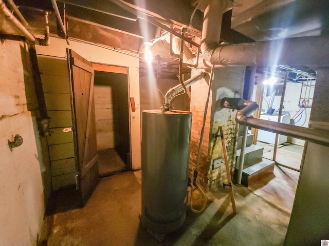 utility room with water heater and washer / dryer