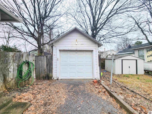 detached garage with driveway and fence