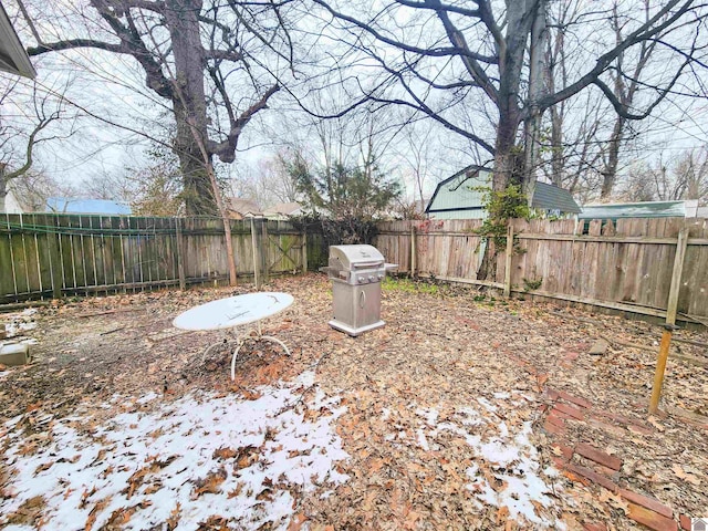 snowy yard with a fenced backyard