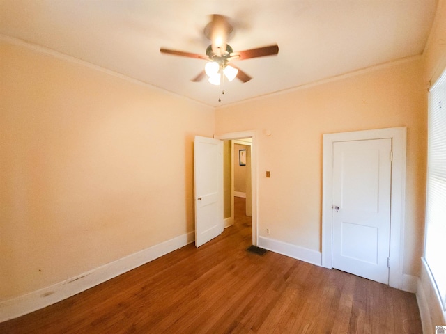 unfurnished bedroom with baseboards, visible vents, ornamental molding, and wood finished floors