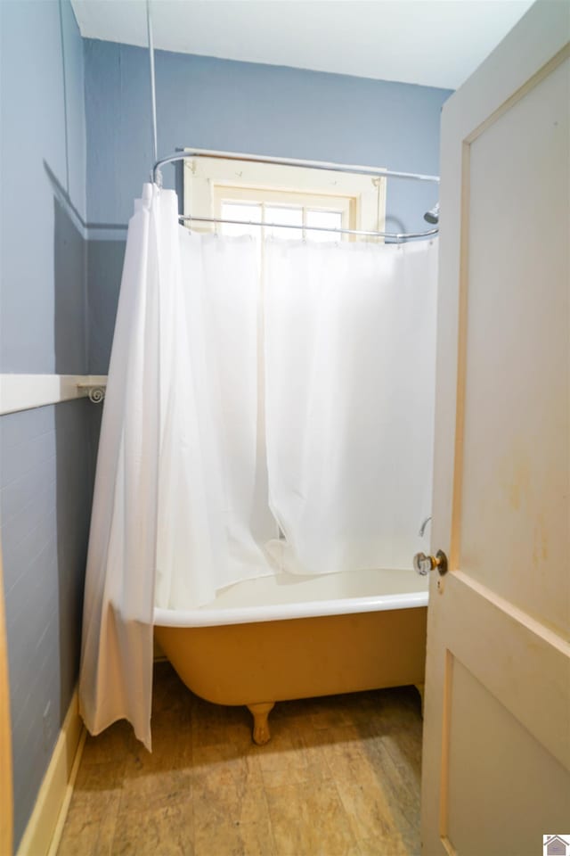 bathroom featuring shower / bath combo and wood finished floors