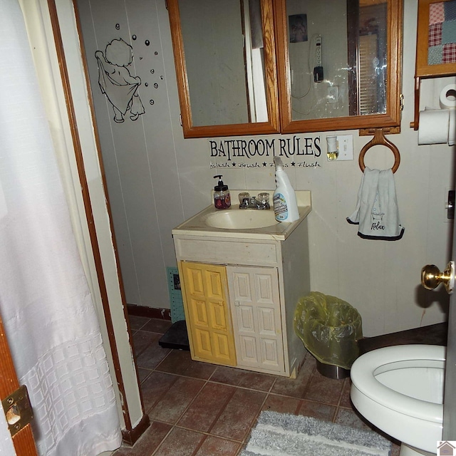 bathroom with toilet, tile patterned flooring, and vanity