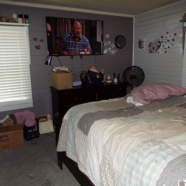 carpeted bedroom featuring wood walls