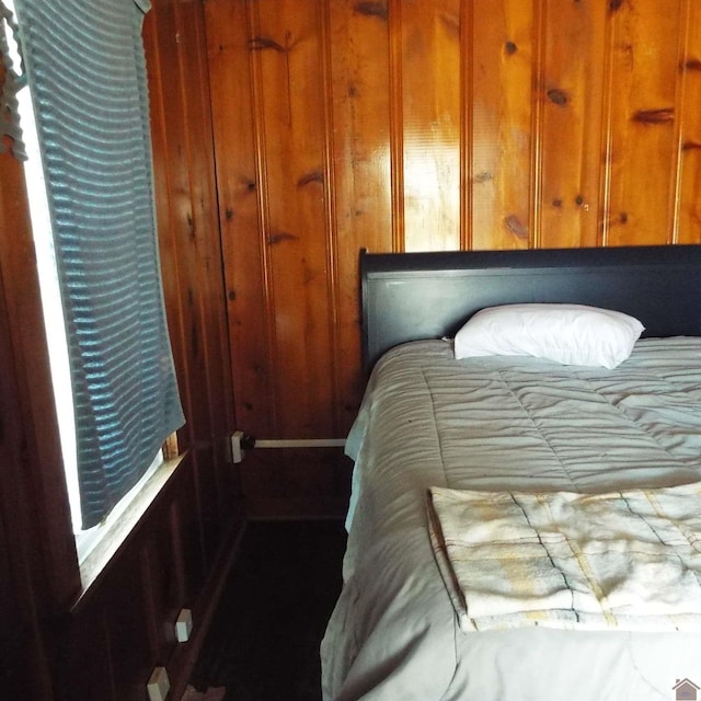 bedroom featuring wood walls